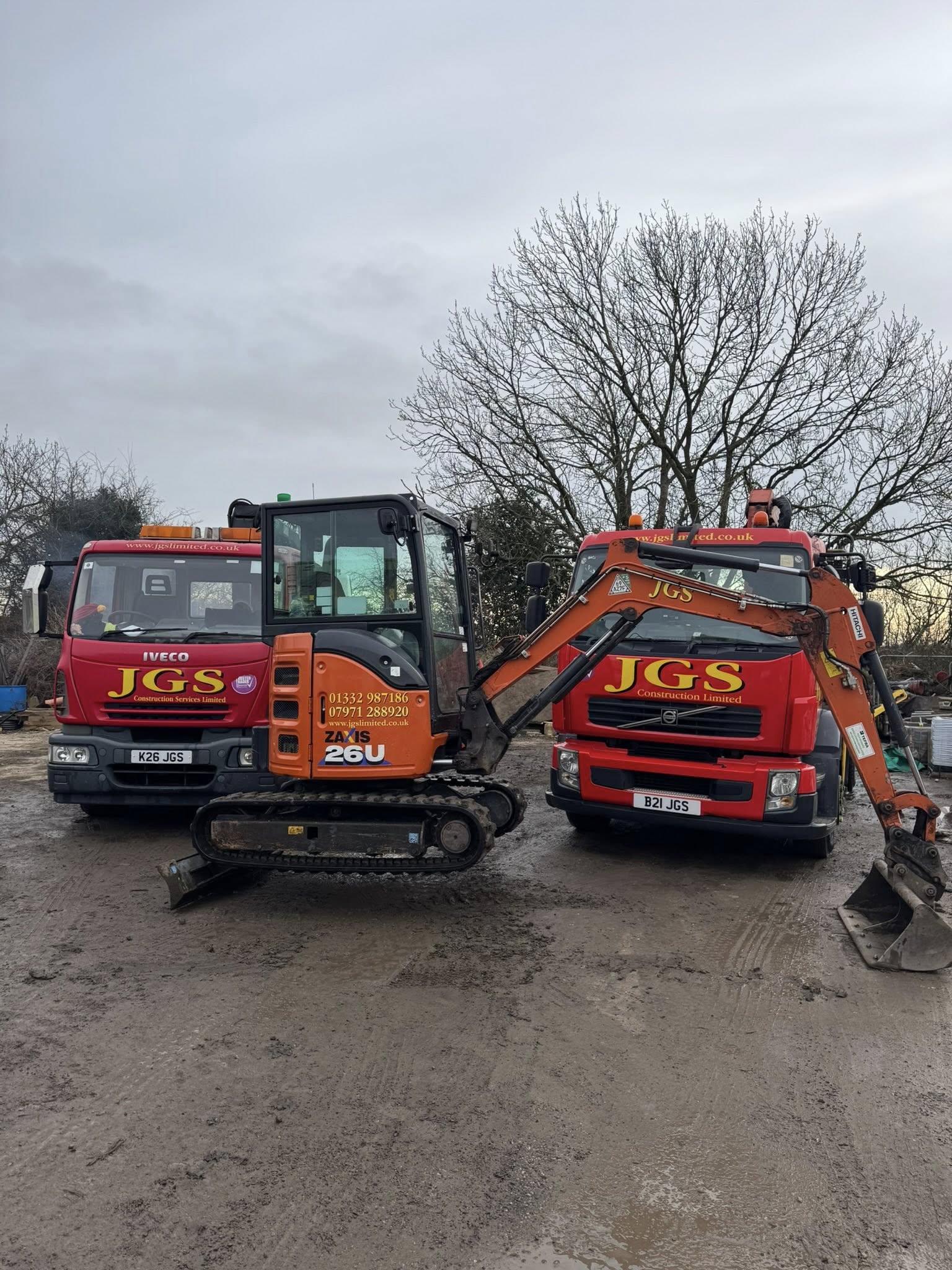 JGS Construction Services Limited fleet — branded tipper lorries and Hitachi mini digger at the Heage, Belper depot, Derbyshire